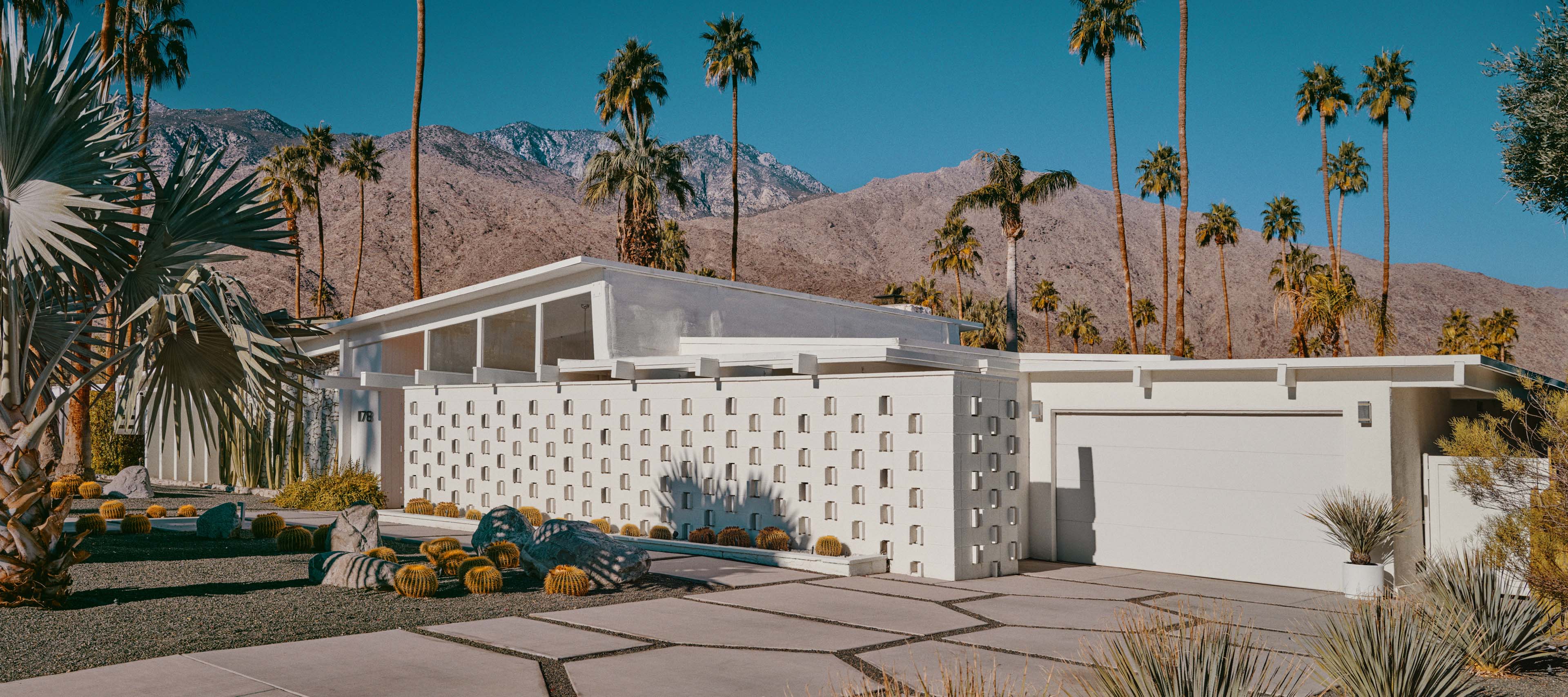 Electromobility and innovations from Mercedes-Benz A suburban white architectural house with a driveway and a garage.