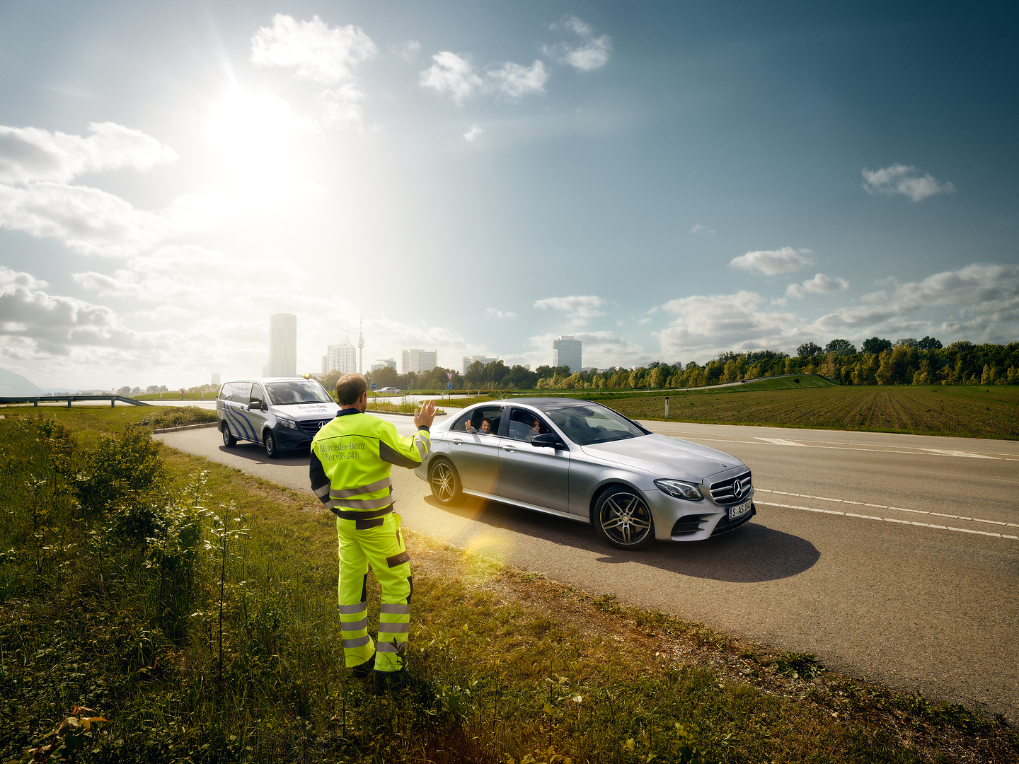 Mercedes-Benz Service24h | Mercedes-Benz A Mercedes-Benz service technician waving from the roadside to a child sitting in an approaching Mercedes.