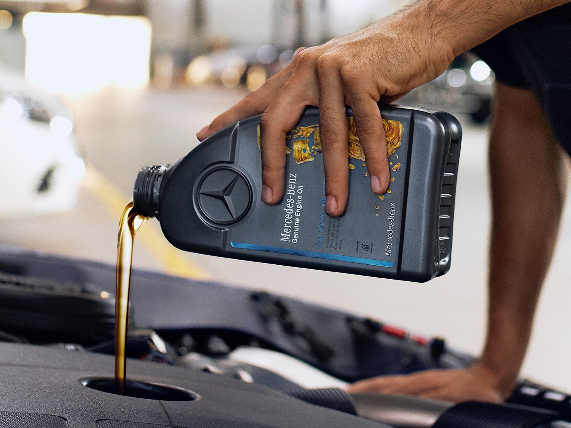 A Mercedes-Benz technician refills genuine engine oil.