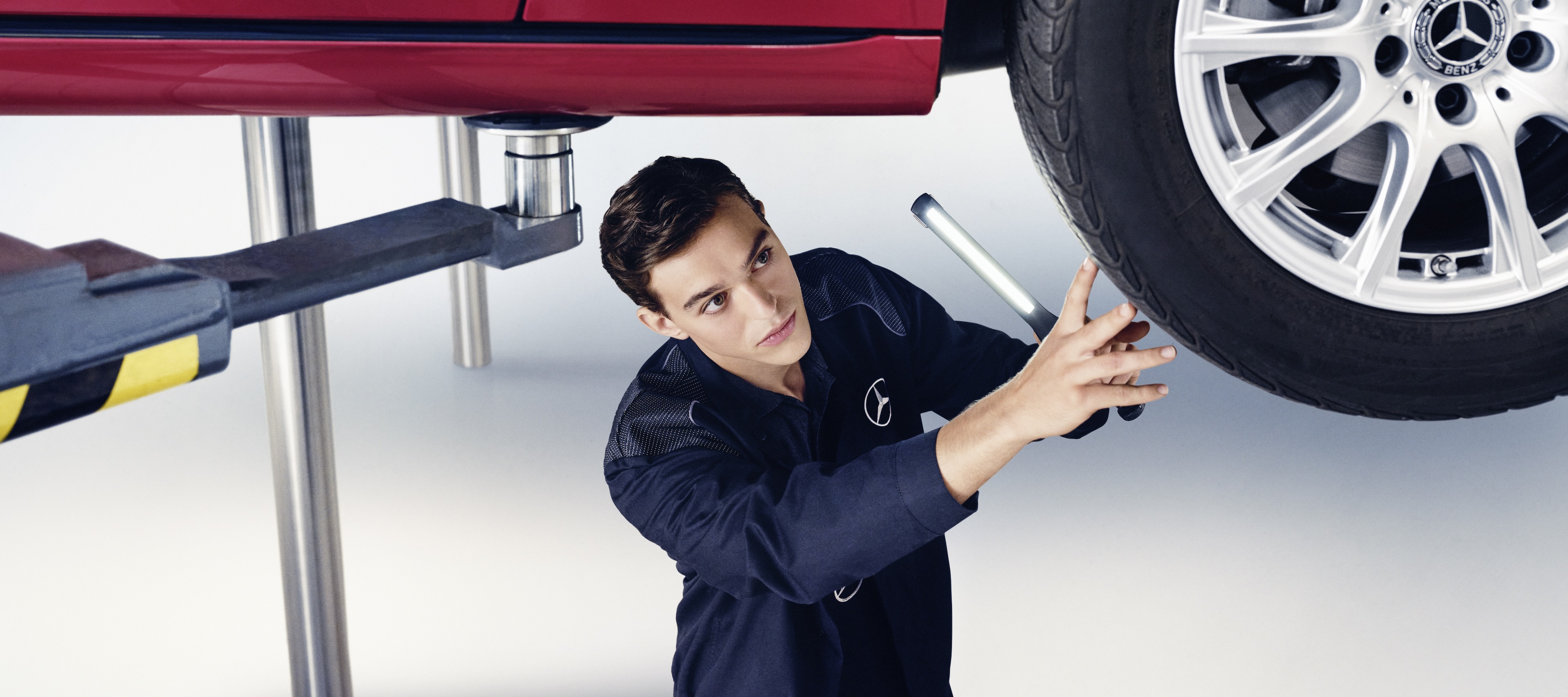 Maintenance Services | Mercedes-Benz A Mercedes-Benz mechanic examines the wheel of a Mercedes-Benz.